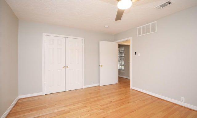 unfurnished bedroom with light wood-type flooring, a closet, and ceiling fan