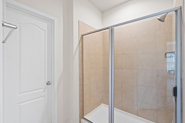 bathroom featuring a shower with shower door