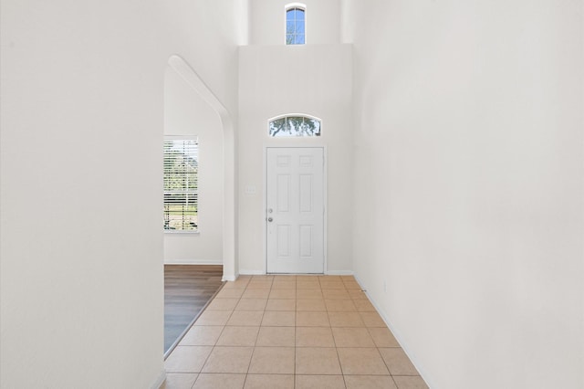 entryway featuring a towering ceiling and light tile patterned floors