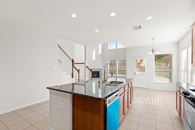 kitchen with range, dishwasher, hanging light fixtures, sink, and a center island with sink