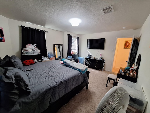 bedroom with light colored carpet and a textured ceiling