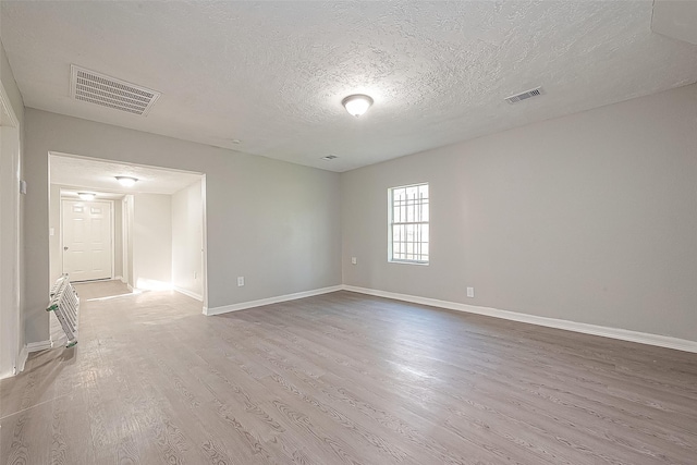 spare room with hardwood / wood-style flooring and a textured ceiling