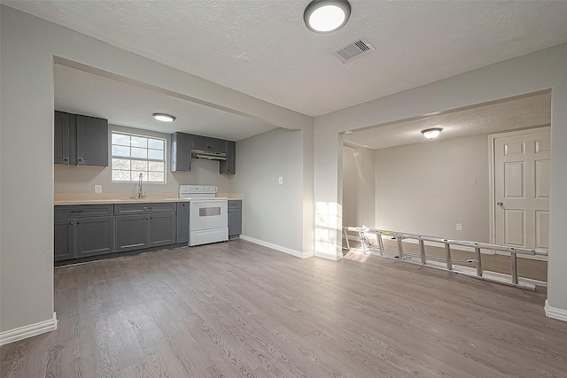 kitchen with a textured ceiling, white range with electric cooktop, light hardwood / wood-style floors, sink, and gray cabinets