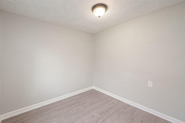 empty room featuring hardwood / wood-style flooring and a textured ceiling