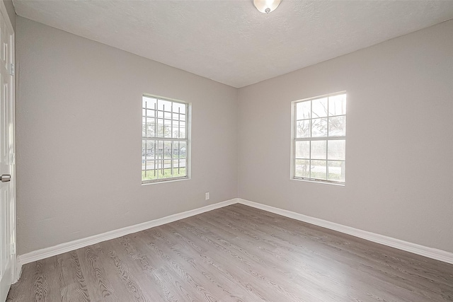 unfurnished room featuring hardwood / wood-style floors and a textured ceiling