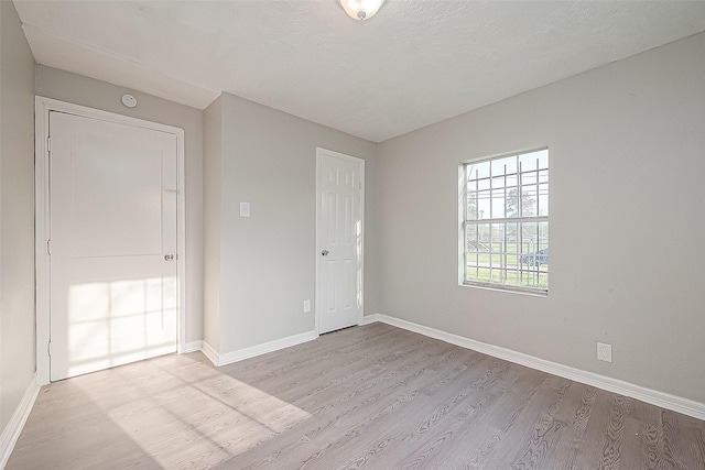 unfurnished room with light wood-type flooring