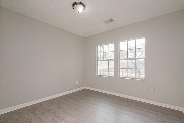 empty room featuring wood-type flooring and a textured ceiling