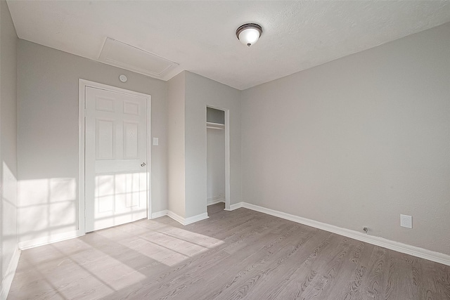 unfurnished bedroom with a closet and light hardwood / wood-style floors