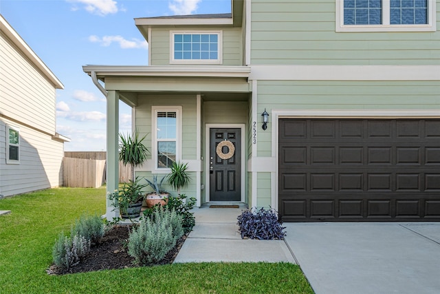 doorway to property with a garage and a yard