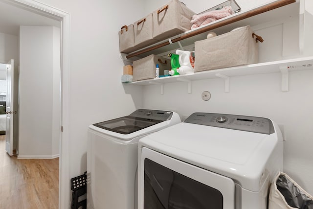 laundry area featuring independent washer and dryer and light wood-type flooring