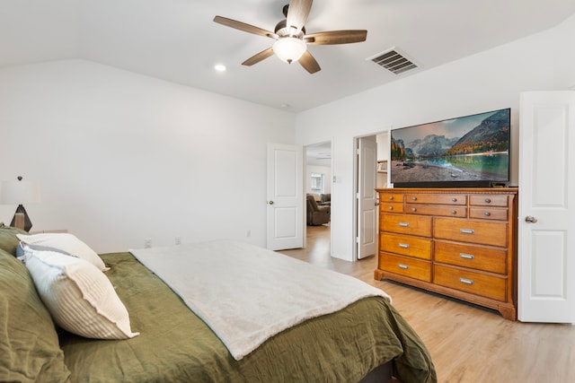 bedroom with light hardwood / wood-style flooring, ceiling fan, and vaulted ceiling