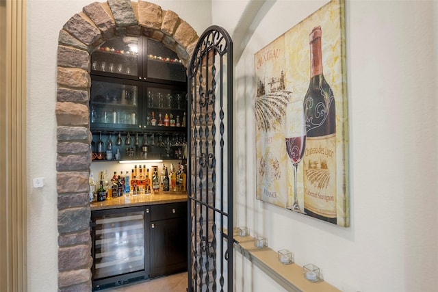 bar featuring beverage cooler, a dry bar, and light tile patterned flooring