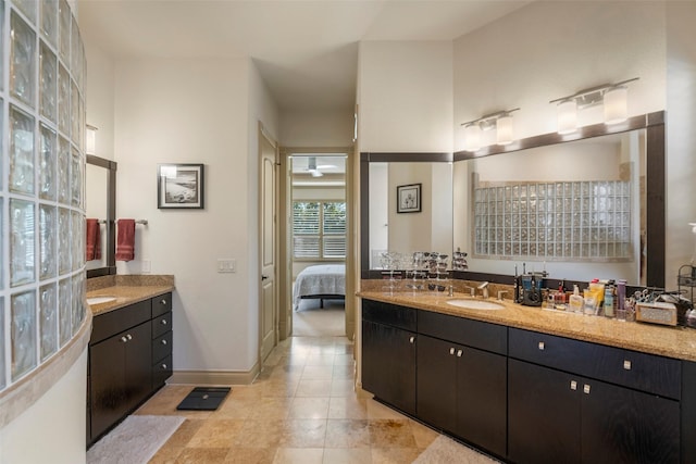 bathroom with ensuite bath, vanity, and baseboards