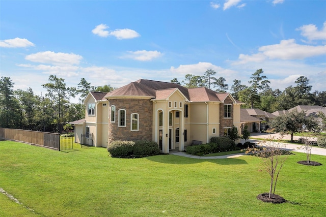 view of front of house featuring a front yard, fence, and stucco siding