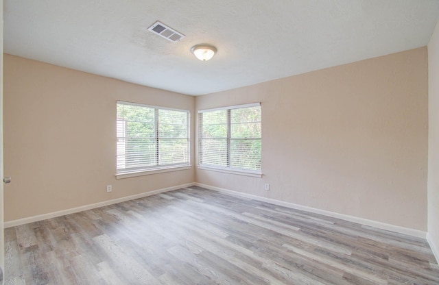 empty room with light hardwood / wood-style flooring