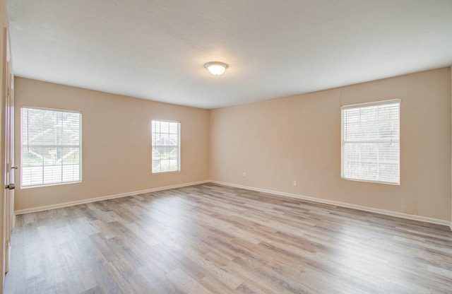 spare room with a healthy amount of sunlight and light hardwood / wood-style floors