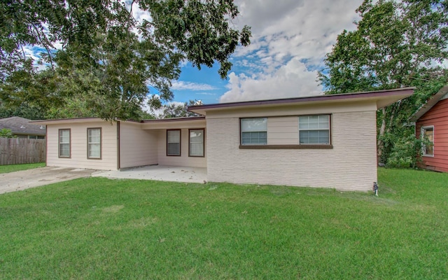 ranch-style house with a front lawn and a patio