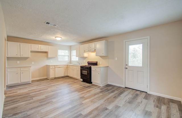 kitchen featuring black gas range oven, white cabinetry, a healthy amount of sunlight, and light hardwood / wood-style floors