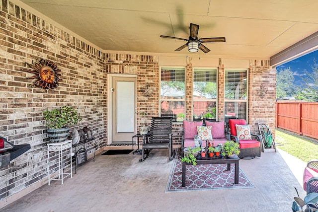 view of patio / terrace featuring fence, an outdoor living space, and a ceiling fan