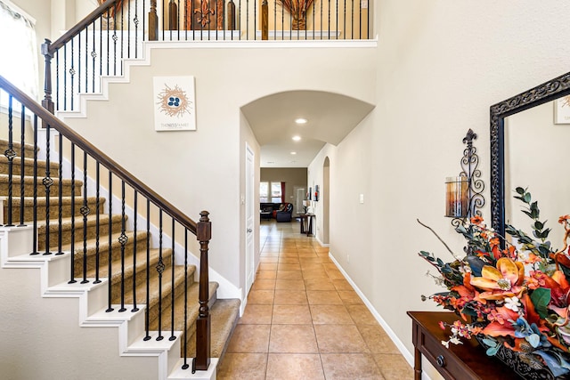 entryway featuring a high ceiling and light tile patterned floors