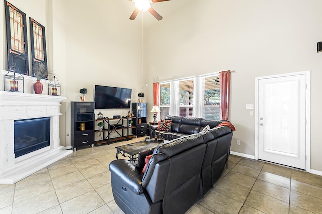 living room featuring ceiling fan, tile patterned floors, and a towering ceiling