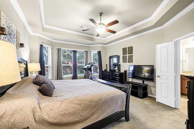 carpeted bedroom with ceiling fan, connected bathroom, crown molding, and a tray ceiling