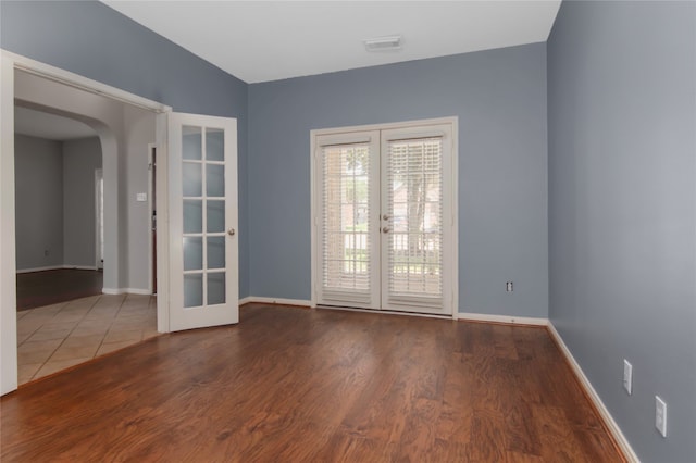 empty room with french doors and wood-type flooring