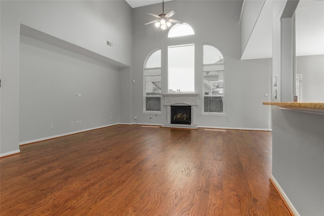 unfurnished living room featuring ceiling fan, high vaulted ceiling, and hardwood / wood-style floors