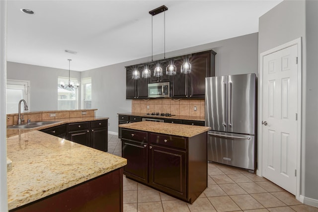 kitchen featuring dark brown cabinets, stainless steel appliances, a center island, and pendant lighting