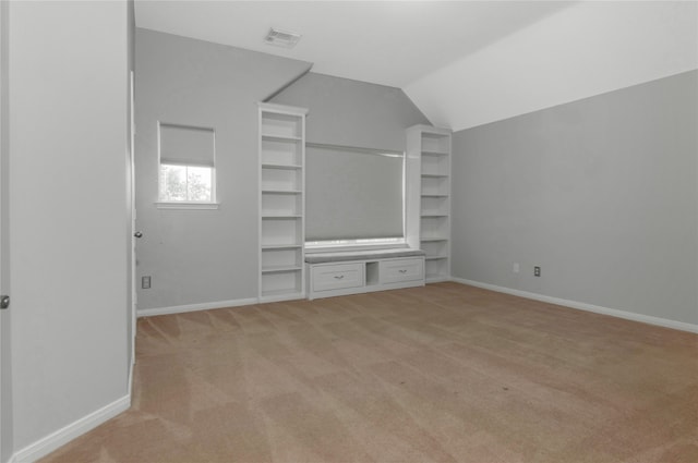 unfurnished bedroom featuring light colored carpet and vaulted ceiling