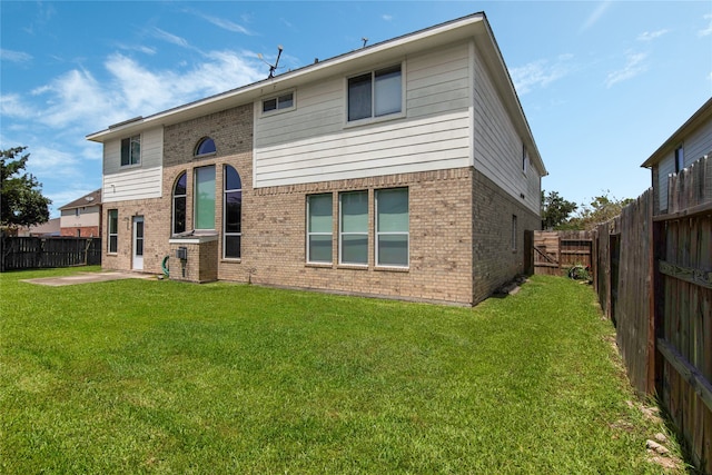 back of property with a patio area and a lawn