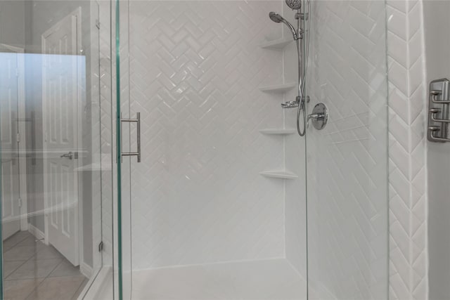 bathroom with an enclosed shower and tile patterned floors