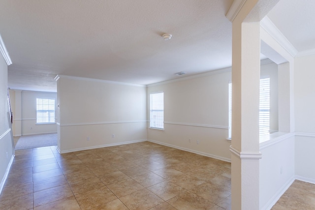 tiled spare room with ornate columns and crown molding