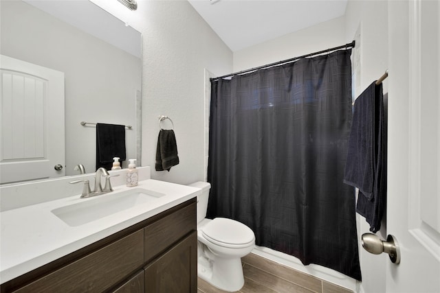 bathroom with toilet, vanity, and walk in shower