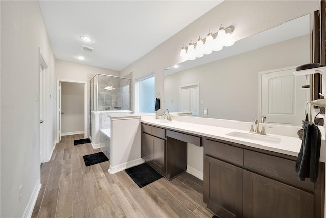 bathroom with independent shower and bath, hardwood / wood-style flooring, and vanity