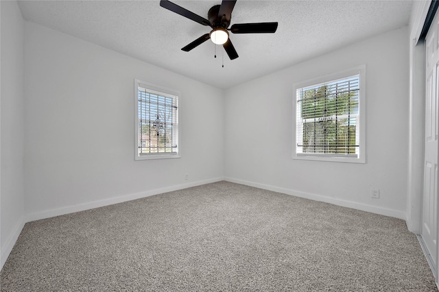 spare room with ceiling fan, carpet, and a textured ceiling