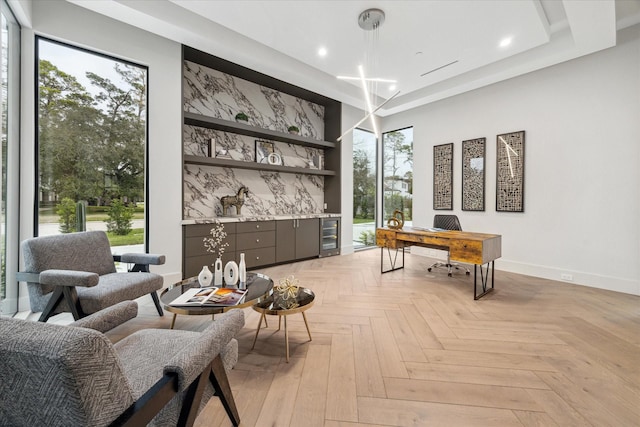 sitting room featuring light parquet flooring, built in features, indoor bar, and wine cooler