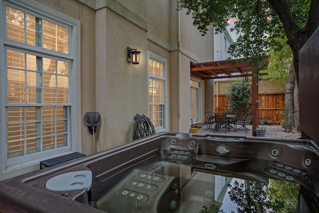 view of patio / terrace with a hot tub and a pergola