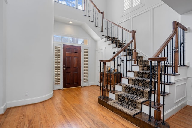 entrance foyer featuring hardwood / wood-style flooring and a towering ceiling