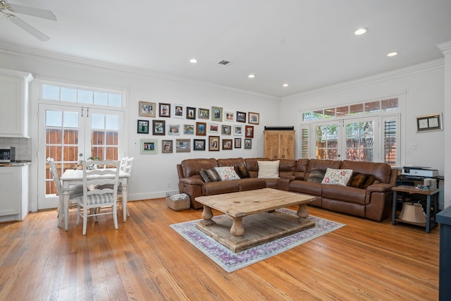 living room with light hardwood / wood-style floors, ceiling fan, crown molding, and french doors