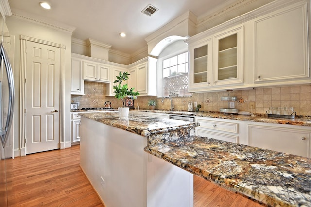 kitchen with dark stone counters, white cabinetry, and decorative backsplash