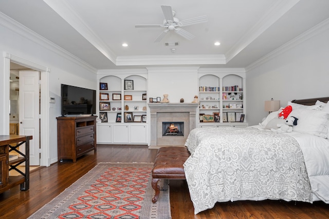 bedroom featuring ceiling fan, dark hardwood / wood-style floors, and a tray ceiling