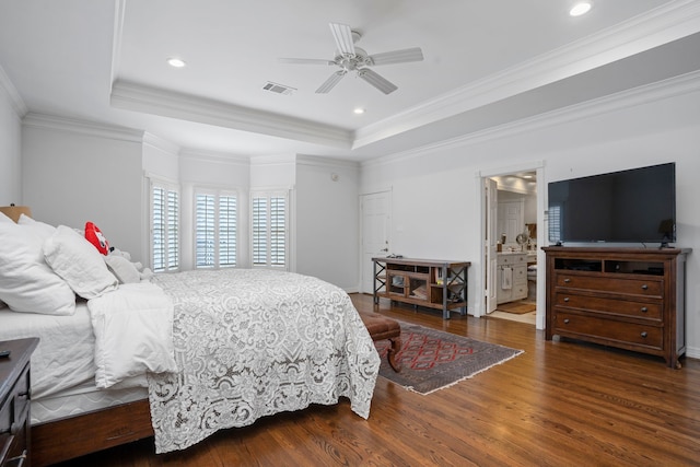 bedroom with ensuite bathroom, crown molding, a raised ceiling, dark wood-type flooring, and ceiling fan