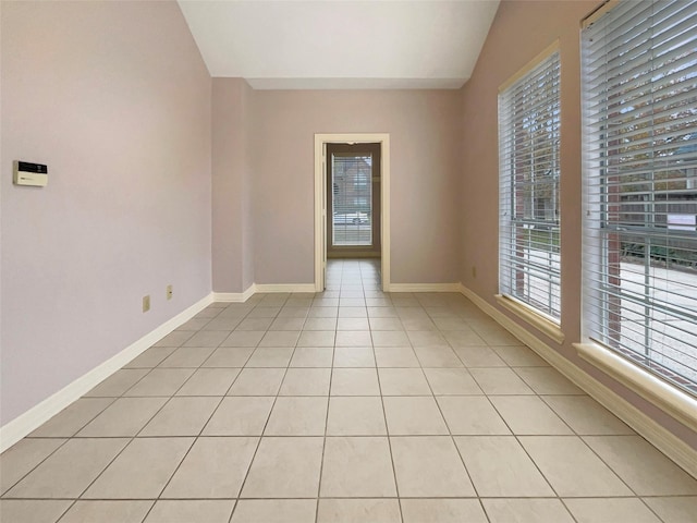 18418 Forest Elms Dr, Spring, TX 77388 - empty room featuring baseboards, light tile patterned flooring, lofted ceiling, and a healthy amount of sunlight