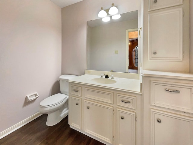 bathroom with vanity, toilet, and hardwood / wood-style floors