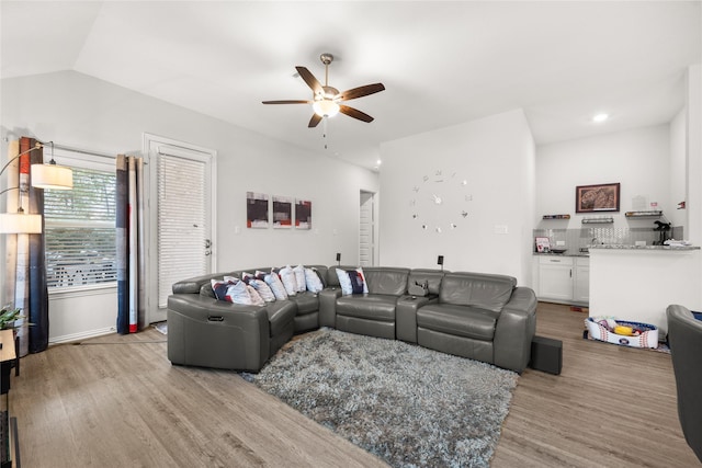 living room with vaulted ceiling, light hardwood / wood-style floors, and ceiling fan