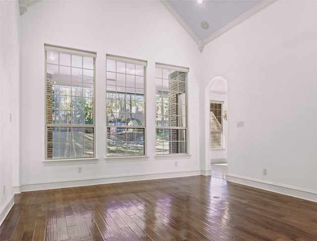 unfurnished room featuring crown molding, dark hardwood / wood-style floors, and high vaulted ceiling