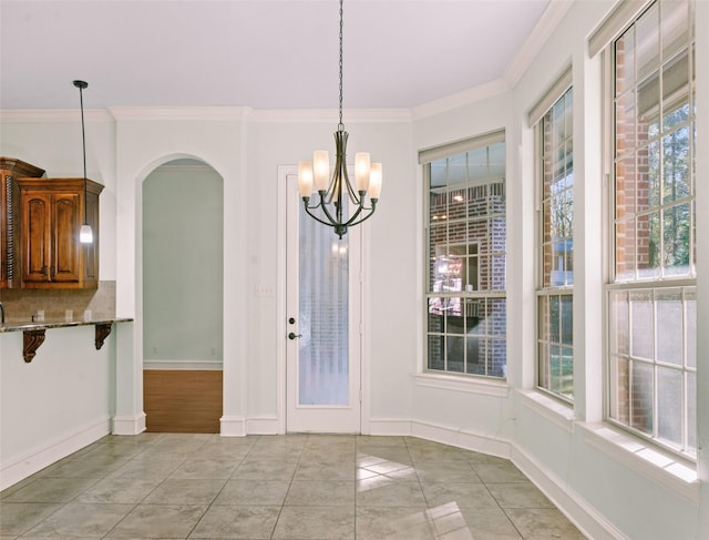 unfurnished dining area with ornamental molding, a chandelier, and light tile patterned flooring