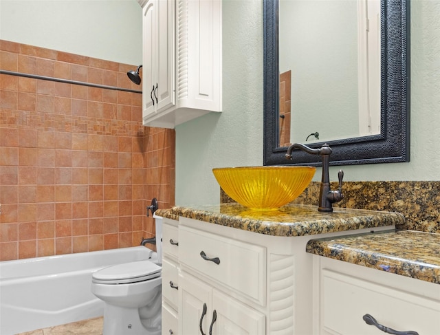 full bathroom with vanity, toilet, and tiled shower / bath combo