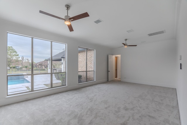 spare room with ceiling fan and light colored carpet